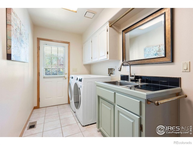 laundry room with cabinet space, washer and dryer, a sink, light tile patterned floors, and visible vents