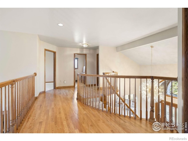 corridor with baseboards, recessed lighting, wood finished floors, and an upstairs landing