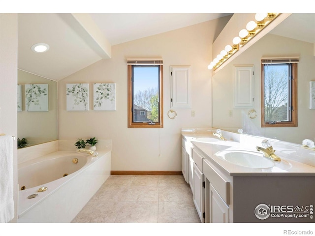 bathroom with baseboards, plenty of natural light, a sink, and lofted ceiling