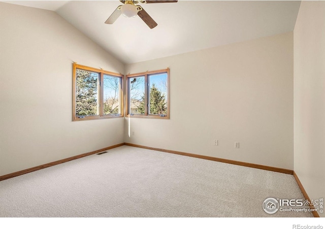unfurnished room featuring baseboards, ceiling fan, vaulted ceiling, and light colored carpet
