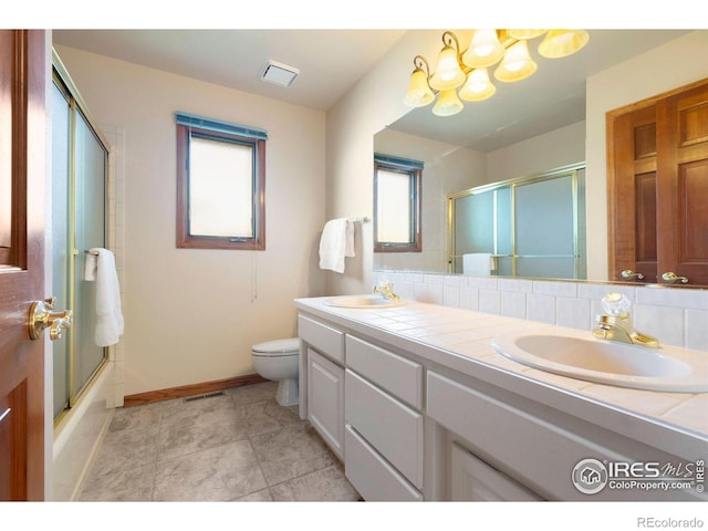 full bath with double vanity, toilet, baseboards, and a sink