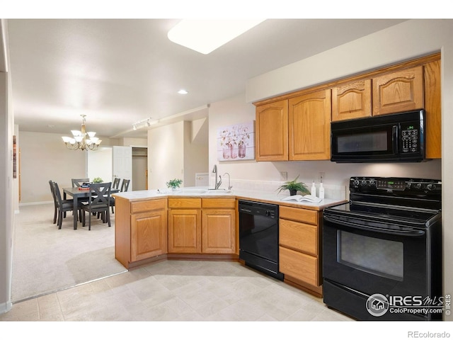 kitchen with light countertops, black appliances, a peninsula, and a chandelier