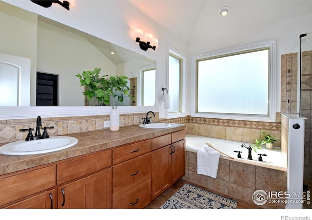 bathroom featuring lofted ceiling, a sink, and a bath