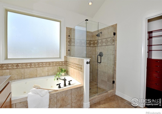 bathroom with vaulted ceiling, a jetted tub, a shower stall, and tile patterned floors