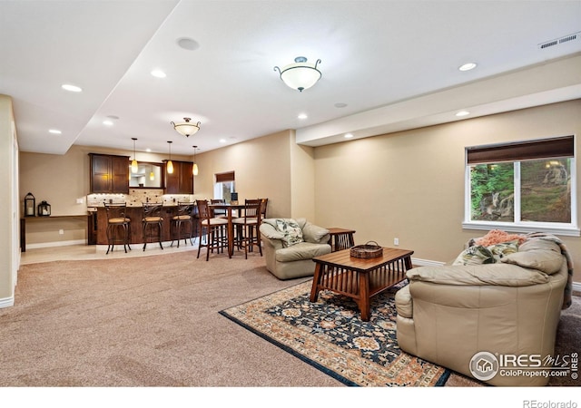 living area featuring light carpet, baseboards, visible vents, and recessed lighting