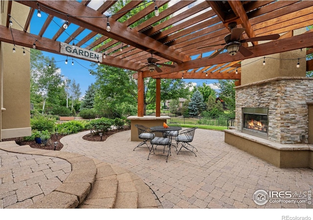 view of patio / terrace featuring an outdoor stone fireplace and a pergola