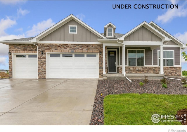 craftsman inspired home featuring concrete driveway, stone siding, board and batten siding, and an attached garage