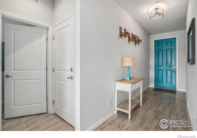 foyer entrance featuring light wood finished floors and baseboards