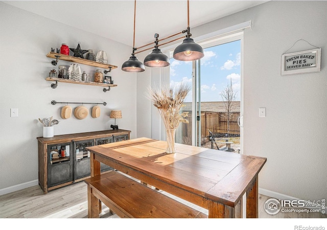 dining area with light wood-style floors and baseboards