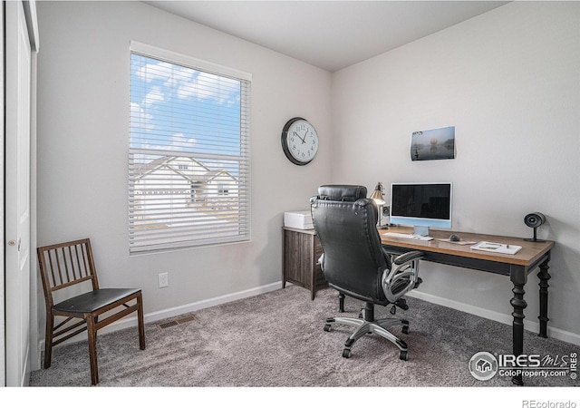 office featuring carpet floors, visible vents, and baseboards