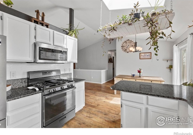 326 Riviera Ln, Johnstown, CO 80534 - kitchen featuring white cabinetry, lofted ceiling, light wood-type flooring, stainless steel appliances, and an inviting chandelier