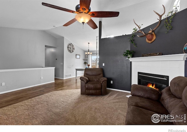 326 Riviera Ln, Johnstown, CO 80534 - living room featuring carpet flooring, visible vents, a tile fireplace, a ceiling fan, and vaulted ceiling
