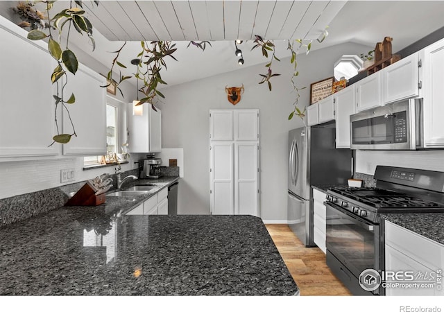 326 Riviera Ln, Johnstown, CO 80534 - kitchen featuring a sink, vaulted ceiling, tasteful backsplash, and appliances with stainless steel finishes