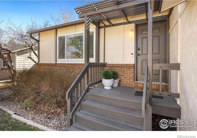 view of exterior entry featuring brick siding