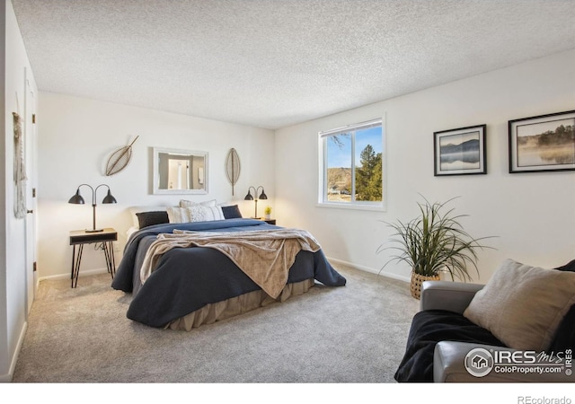 bedroom featuring light carpet, baseboards, and a textured ceiling