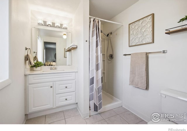 bathroom featuring a stall shower, tile patterned flooring, vanity, and toilet