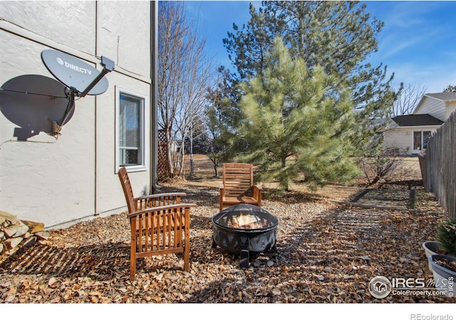 view of yard featuring fence and a fire pit