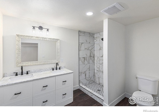 full bathroom with wood finished floors, a sink, visible vents, and baseboards