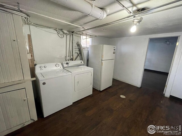 clothes washing area featuring dark wood-style floors, laundry area, a textured ceiling, and washing machine and dryer