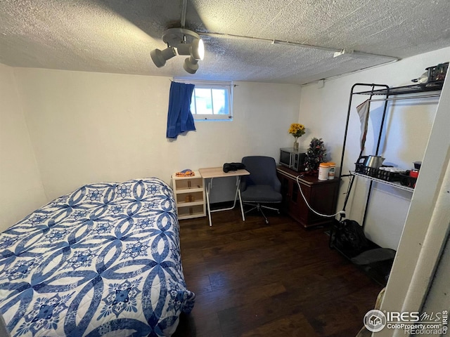 bedroom featuring ceiling fan, a textured ceiling, and wood finished floors