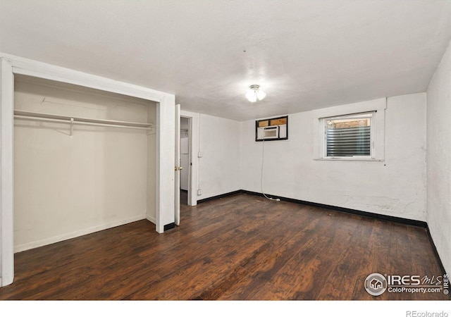 unfurnished bedroom featuring baseboards and dark wood-style flooring