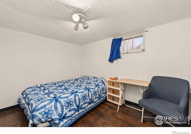 bedroom with baseboards, a textured ceiling, a ceiling fan, and wood finished floors