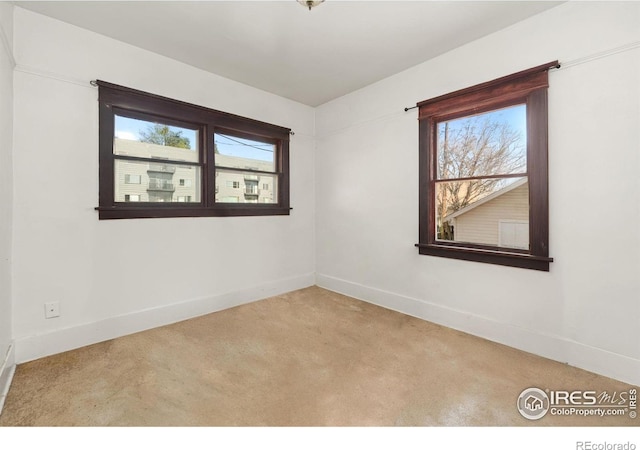 carpeted spare room with baseboards