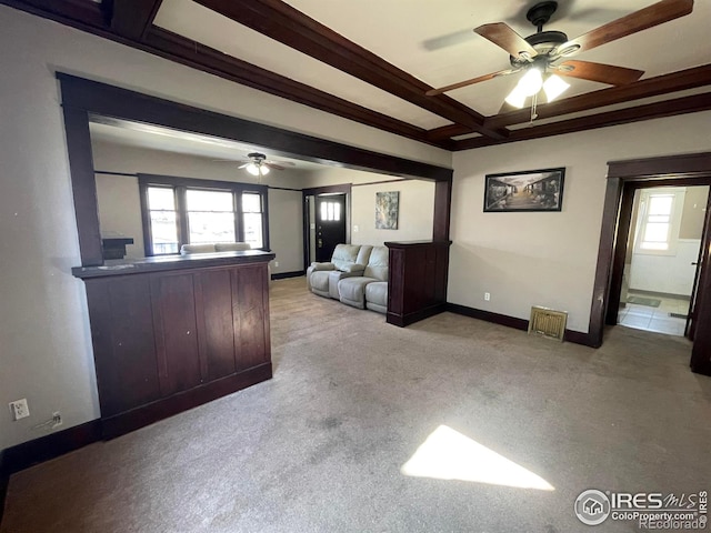 unfurnished living room with plenty of natural light, baseboards, coffered ceiling, and carpet flooring