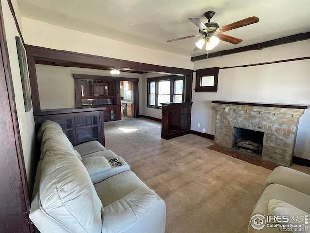 carpeted living area featuring a fireplace with flush hearth, a ceiling fan, and baseboards