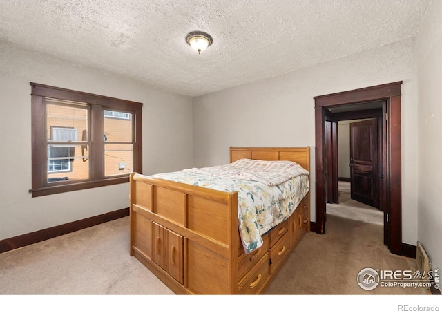 bedroom with light colored carpet, a textured ceiling, and baseboards