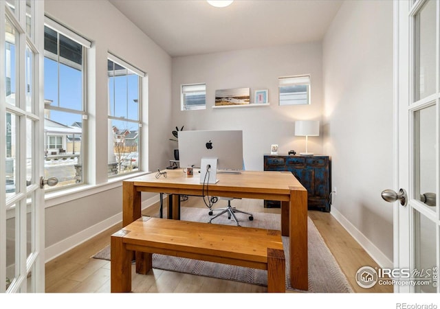 office area with french doors, light wood-type flooring, and baseboards