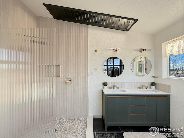 full bath with double vanity, a tile shower, and a sink