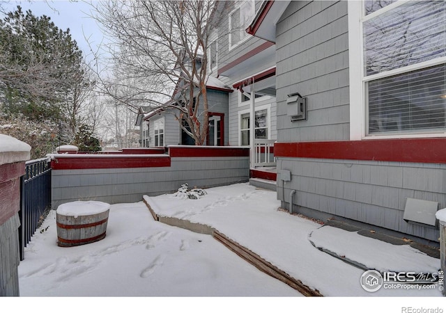 snow covered property featuring fence