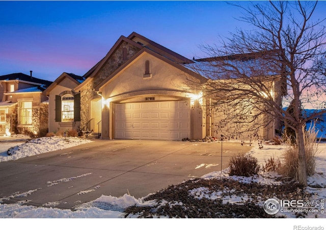 view of front of house with driveway, an attached garage, and stucco siding