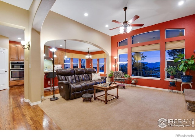 2185 Diamond Creek Dr, Colorado Springs, CO 80921 - living area featuring arched walkways, a high ceiling, ceiling fan with notable chandelier, light wood-style floors, and recessed lighting