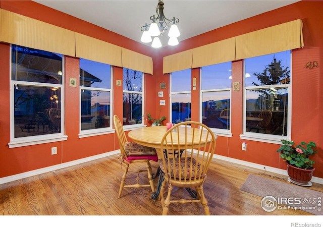 2185 Diamond Creek Dr, Colorado Springs, CO 80921 - dining room with light wood-style flooring, visible vents, baseboards, and a notable chandelier