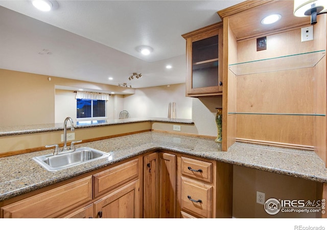 2185 Diamond Creek Dr, Colorado Springs, CO 80921 - kitchen with glass insert cabinets, light stone counters, a sink, and recessed lighting