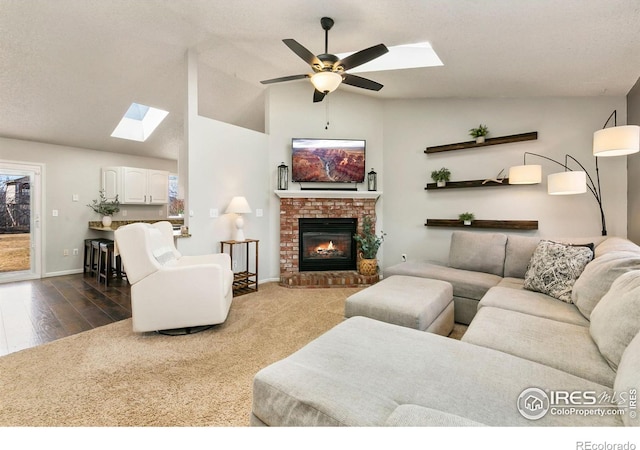 living room featuring a fireplace, lofted ceiling, ceiling fan, wood finished floors, and baseboards