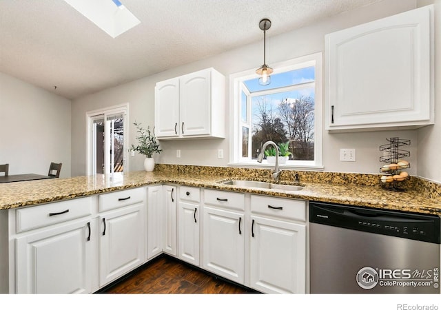 kitchen with pendant lighting, stainless steel dishwasher, stone countertops, white cabinets, and a sink