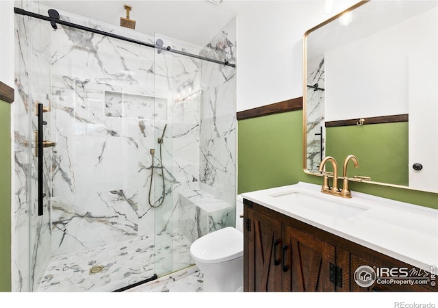 full bath featuring toilet, marble finish floor, a marble finish shower, and vanity