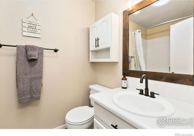 bathroom with toilet, curtained shower, and vanity