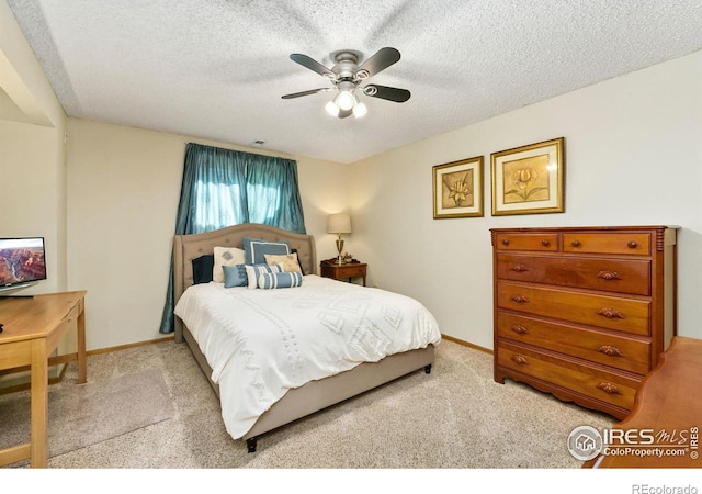 bedroom featuring a textured ceiling, ceiling fan, baseboards, and light colored carpet