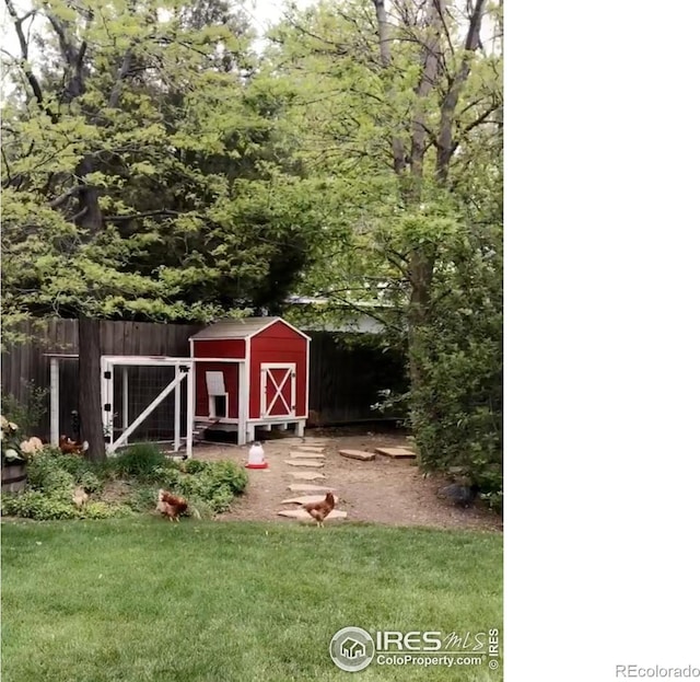 view of poultry coop featuring a yard and fence