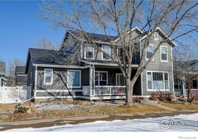 view of front of home featuring covered porch and fence