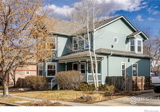 view of front of home featuring a porch and fence