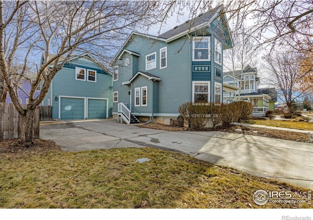 view of front of property with concrete driveway, an attached garage, and fence