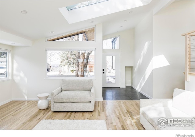 foyer entrance with a healthy amount of sunlight, a skylight, and wood finished floors