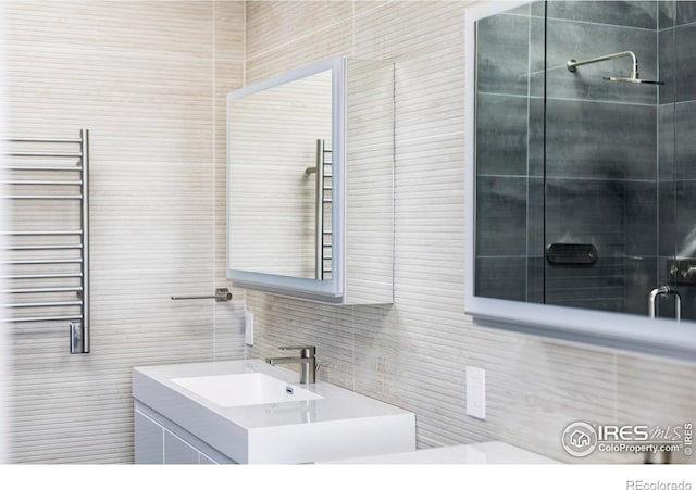 bathroom featuring radiator, tile walls, and vanity