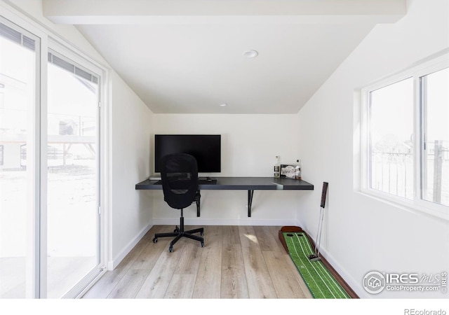 office featuring baseboards, lofted ceiling, and light wood-style floors