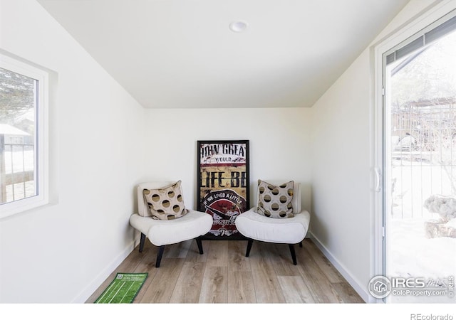 living area featuring light wood-style flooring and baseboards